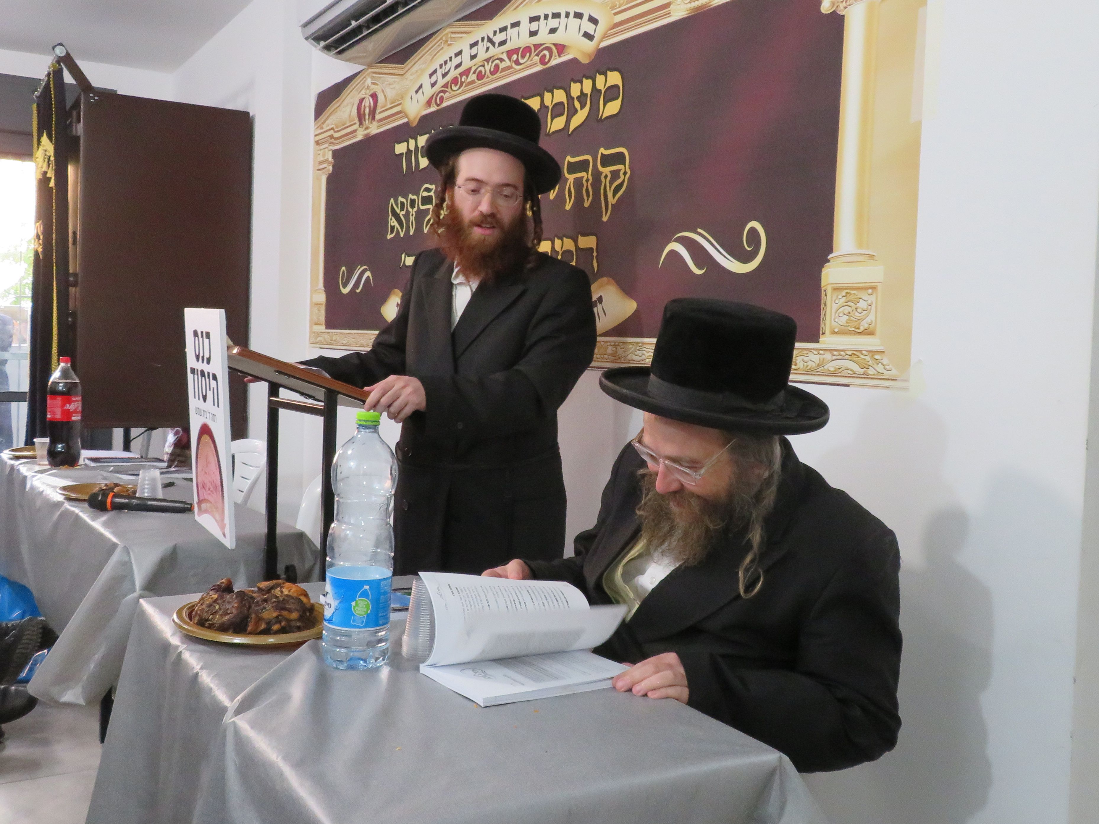 הגאון ר שמואל יעקב לנדאו מעיין בספר שחולק למזכרת.jpg