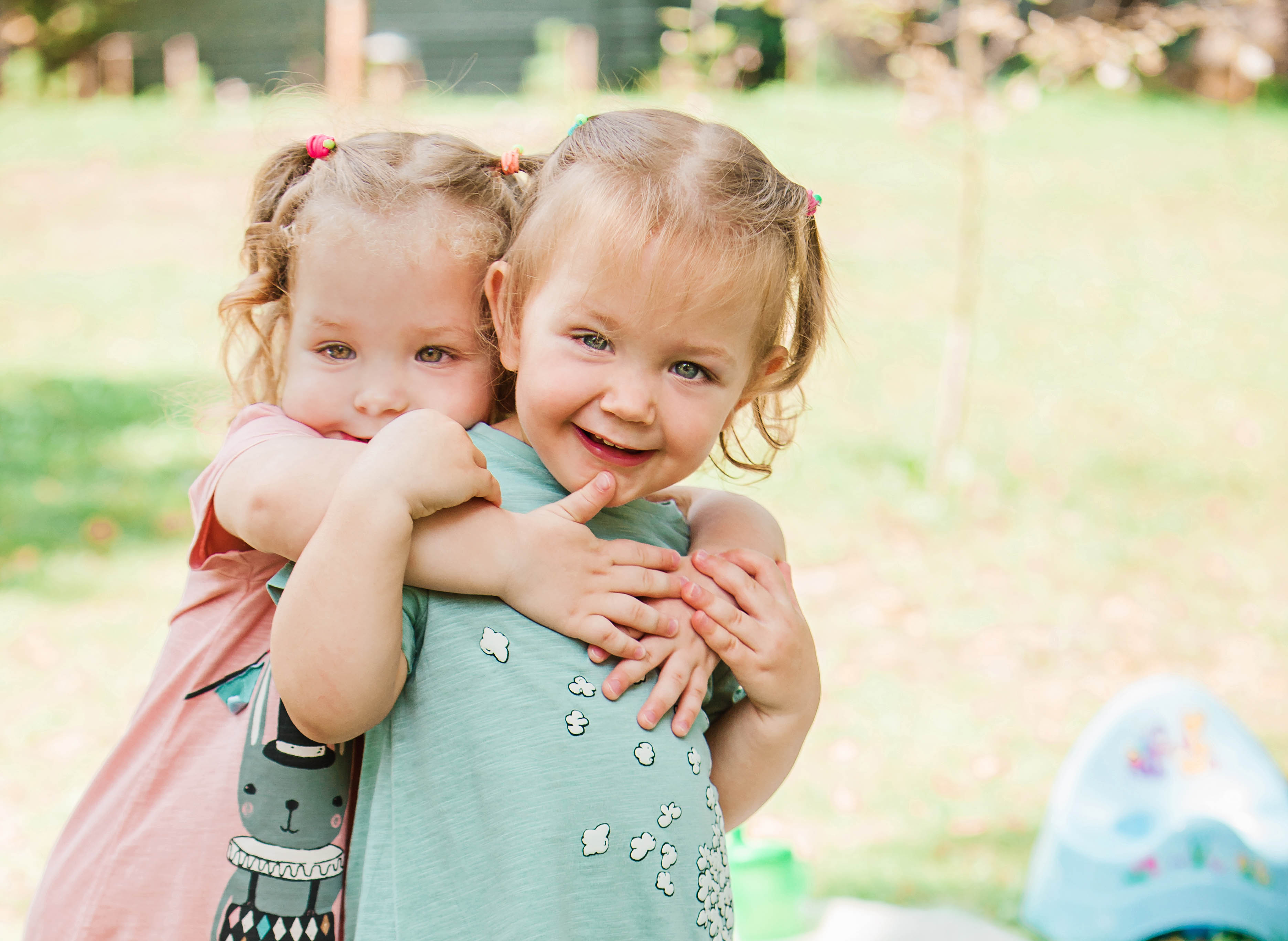 two-little-baby-girls-playing-against-green-grass2.jpg